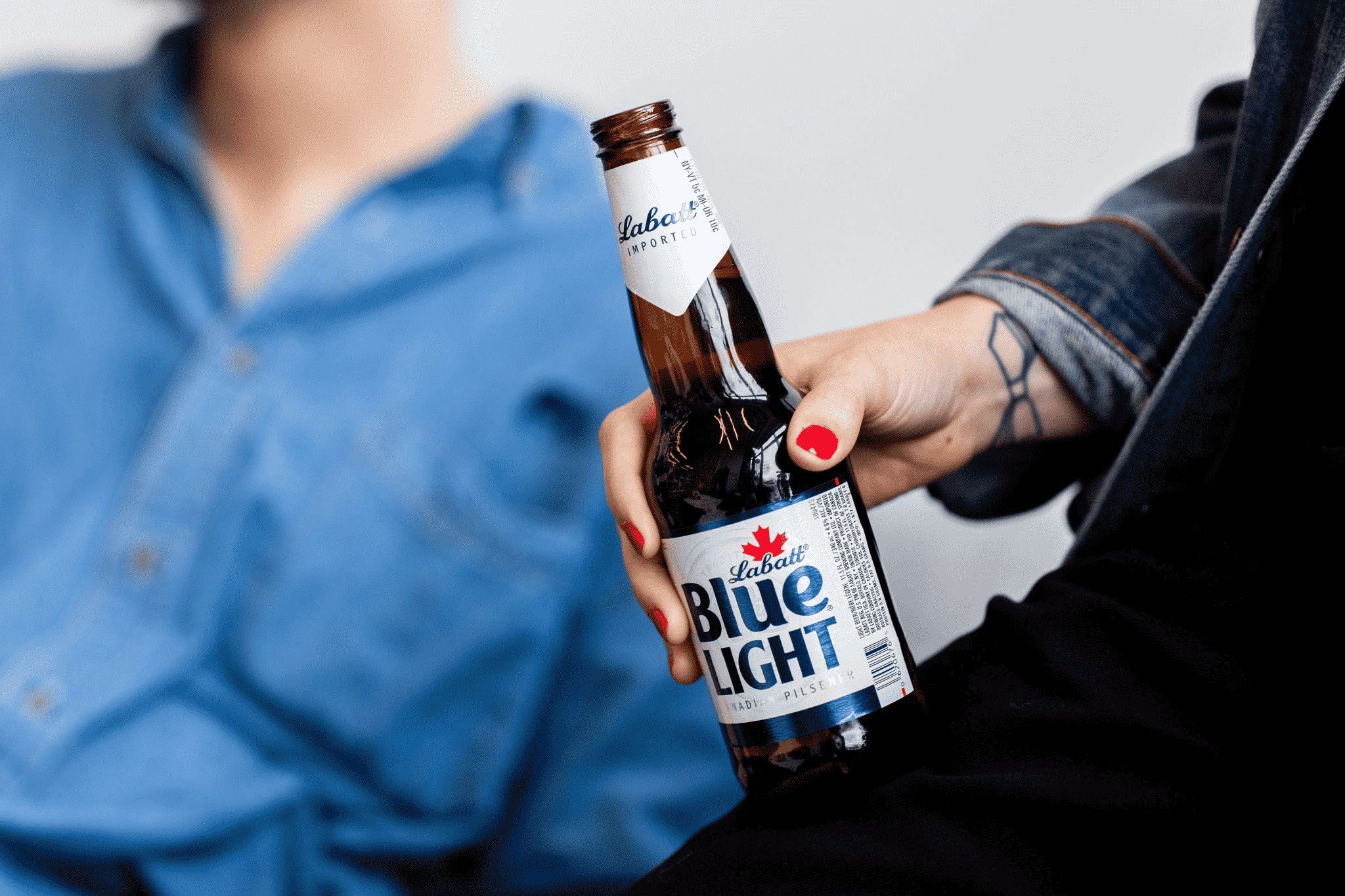 Photograph of a hand holding a bottle of Labatt Blue Light